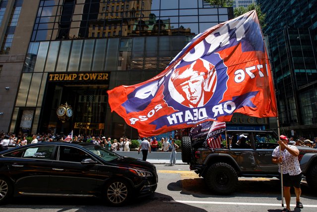 A man carries a flag in support of Republican presidential candidate and former President Donald Trump, after Trump was injured when shots were fired during a campaign rally held in Butler, Pennsylvania, outside Trump Tower in New York on July 14, 2024. (Photo by Eduardo Munoz/Reuters)