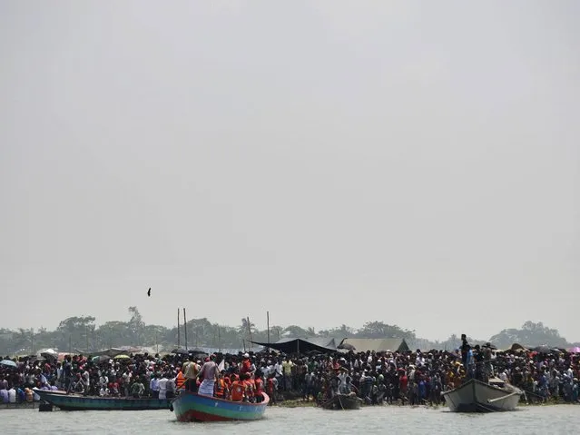Bangladeshi residents gather near the site where a ferry capsized on the river Meghna in Munshiganj district. (Photo by Munir Uz Zaman/AFP Photo)