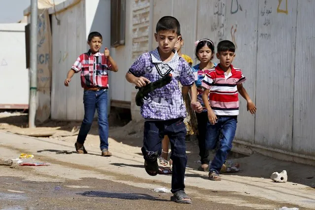 Syrian refugee children play with toy guns during the first day of Eid al-Fitr, marking the end of the holy month of Ramadan, at the Al-Zaatari refugee camp in Mafraq, Jordan, near the border with Syria, July 17, 2015. (Photo by Muhammad Hamed/Reuters)
