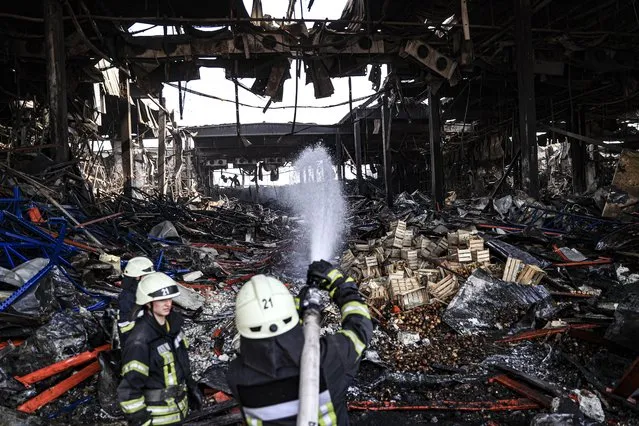 Firefighters works in the logistics warehouse, which contained 50 thousand tons of food while it was bombed on 13 March in the Brovary region, as Russian attacks continue near Kyiv, Ukraine on March 29, 2022. (Photo by Metin Aktas/Anadolu Agency via Getty Images)