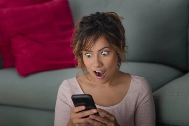 Woman surprised at message on smartphone. (Photo by Steve Prezant/Getty Images)