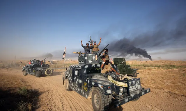 Iraqi pro-government forces advance towards the city of Fallujah on May 23, 2016, as part of a major assault to retake the city from Islamic State (IS) group. Iraqi forces, consisting of special forces, soldiers, police, militia forces and pro-government tribesmen, launched a major assault to retake Fallujah, the scene of deadly battles during the US occupation and one of the toughest targets yet in Baghdad's war on the Islamic State group. Prime Minister Haider al-Abadi, commander-in-chief of the armed forces, announced the start of operations in the middle of the night and then visited the battle's operations room. (Photo by Ahmad Al-Rubaye/AFP Photo)