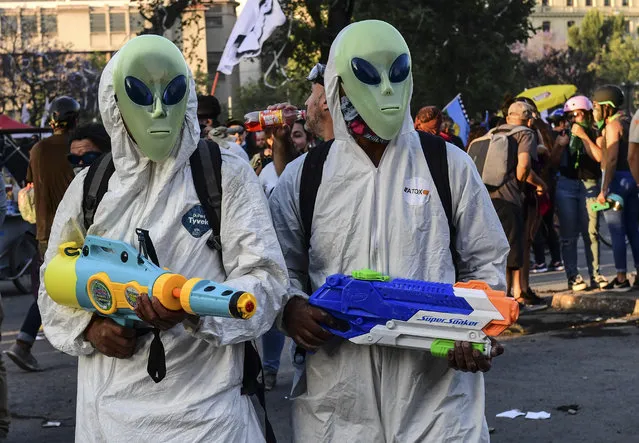Demonstrators take part in a protest against the government and to commemorate the first anniversary of the death of Mapuche indigenous leader Camilo Castrillanca – killed in a police operation – in Santiago, on November 14, 2019. The demonstrators are demanding greater social reform from President Sebastian Pinera, who has announced several measures in a bid to appease protesters, including a pledge to change the constitution that dates from the 1973-90 Augusto Pinochet dictatorship. (Photo by Martin Bernetti/AFP Photo)