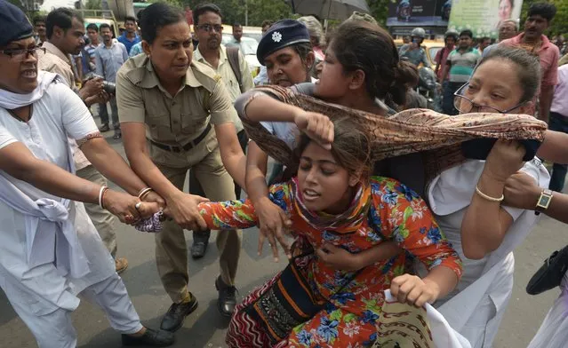 Indian police arrest activists from the Social Unity Centre of India (SUCI) organisation as they block a road during a protest against a gang rape in Kolkata on May 31, 2016. A woman was kidnapped and gang-raped by at least four men on May 29 in the Salt Lake area of the city and is currently being treated in hopsital, local media reported. (Photo by Dibyangshu Sarkar/AFP Photo)