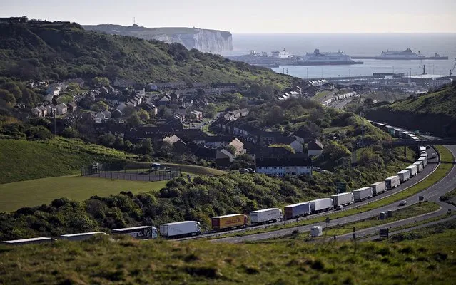 Freight lorries and HGVs (heavy goods vehicles) queue on the A20 road towards the Port of Dover, as the P&O ferry “Spirit of Canterbury” (R) is pictured moored to the quayside at the port, on the south-east coast of England, on April 26, 2022. (Photo by Ben Stansall/AFP Photo)