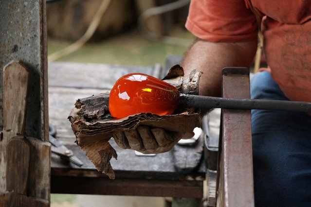 Glassmaker Eduardo Viciana works on molten glass in his atelier in Havana, Cuba, on June 21, 2024. (Photo by Alexandre Meneghini/Reuters)