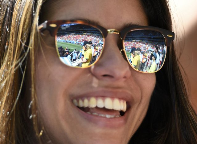 A partial view of the stadium and its spectators are seen reflected in a fan's sunglasses as she waits for the start of the 2014 World Cup quarter-finals between Argentina and Belgium at the Brasilia national stadium in Brasilia July 5, 2014. (Photo by Dylan Martinez/Reuters)