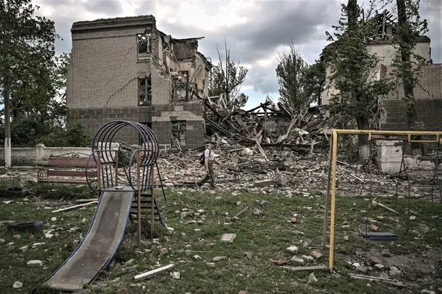 A man walks in front of a destroyed school in the city of Bakhmut, in the eastern Ukranian region of Donbas on May 28, 2022, on the 94th day of Russia's invasion of Ukraine. (Photo by Aris Messinis/AFP Photo)