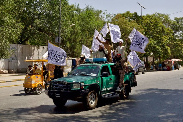 Members of the Taliban carrying flags participate in a rally to mark the third anniversary of the fall of Kabul, in Kabul, Afghanistan on August 14, 2024. (Photo by Sayed Hassib/Reuters)