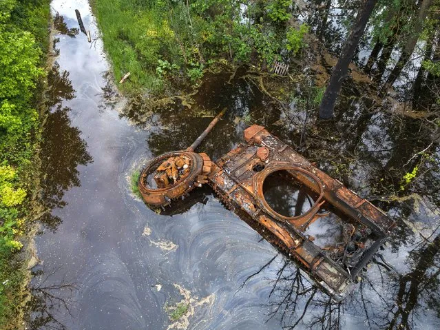 A burnt tank is seen in the overflowed Uhor river on May 31, 2022 in Kolychivka, Ukraine. (Photo by Alexey Furman/Getty Images)