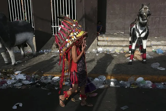 A woman dressed as an indigenous person walks outside a church during celebrations honouring the patron saint of Managua, Santo Domingo de Guzman, in Managua, Nicaragua August 9, 2015. (Photo by Oswaldo Rivas/Reuters)