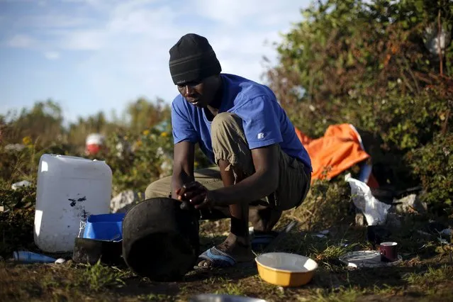 Khalifa, from Sudan washes a pot at “The New Jungle” camp in Calais, France, August 8, 2015. (Photo by Juan Medina/Reuters)