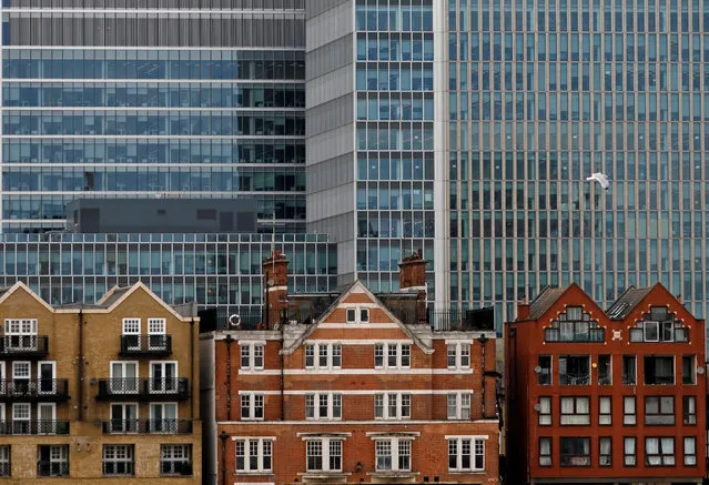 Apartment buildings are backdropped by skyscrapers of banks at Canary Wharf in London, Britain October 30, 2015. (Photo by Reinhard Krause/Reuters)