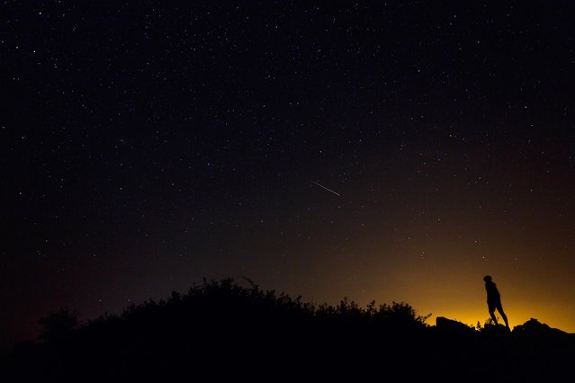 A Perseid meteor along the Milky Way illuminates the dark sky near Villadiego in the province of Burgos, northern Spain, during the “Perseids” meteor shower on August 12, 2015. (Photo by Cesar Manso/AFP Photo)