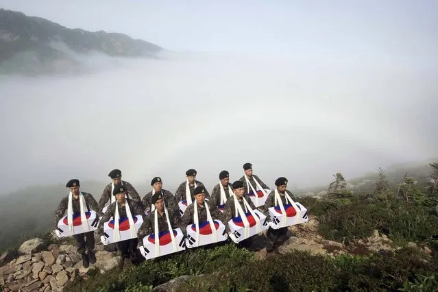 Soldiers pay a silent tribute after completing the exhumation of the remains of South Korean soldiers, who are believed to have been killed by North Korean soldiers during the 1950-53 Korean War at an excavation site on a mountain in Sokcho June 14, 2012