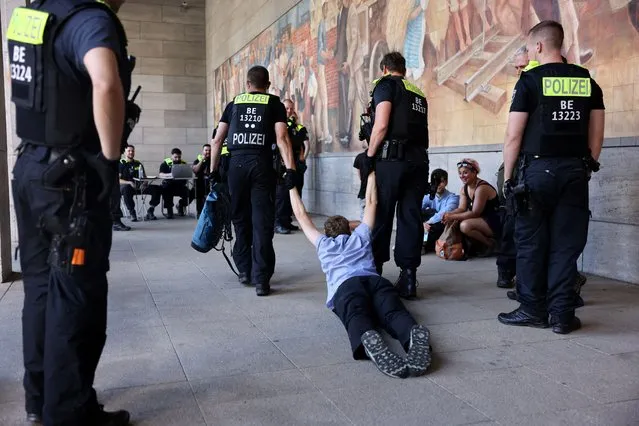 Police officers remove an activist during a demonstration blocking the German Ministry of Finance to demand a debt relief for countries of the global south, while the G7 summit takes place in Elmau, in Berlin, Germany, June 27, 2022. (Photo by Christian Mang/Reuters)