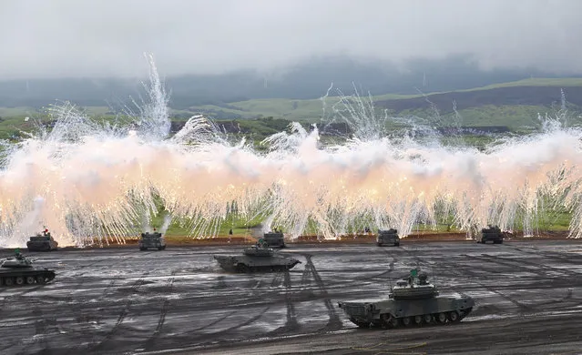 Japan Ground Self-Defense Force's Type-89 armored combat vehicles flare up a smoke screen during an annual live firing exercise at Higashi Fuji range in Gotemba, southwest of Tokyo, Tuesday, August 18, 2015. (Photo by Shizuo Kambayashi/AP Photo)