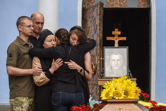 Relatives, friends, and comrades of Ukrainian serviceman Andrii Verkhoglyad attend his funeral ceremony at St. Michael's Golden-Domed Monastery in Kyiv (Kiev), Ukraine, 08 July 2022. Andrii, commander of the 3rd battalion of the 72nd infantry brigade, was killed in combat on 23 June near Svitlodarsk, Donetsk Oblast, amid the Russian invasion of Ukraine. (Photo by Oleg Petrasyuk/EPA/EFE)