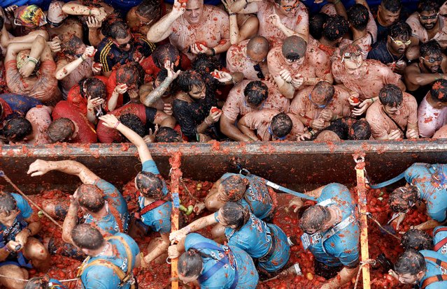 People participate in La Tomatina, a traditional and world-wide known tomato fight festival, in Bunol, Valencia province, eastern Spain, 30 August 2023. As every year on the last Wednesday of August, thousands of people visit the small village of Bunol to attend the Tomatina, a battle in which tons of ripe tomatoes are used to throw at each other. (Photo by Miguel Angel Polo/EPA)