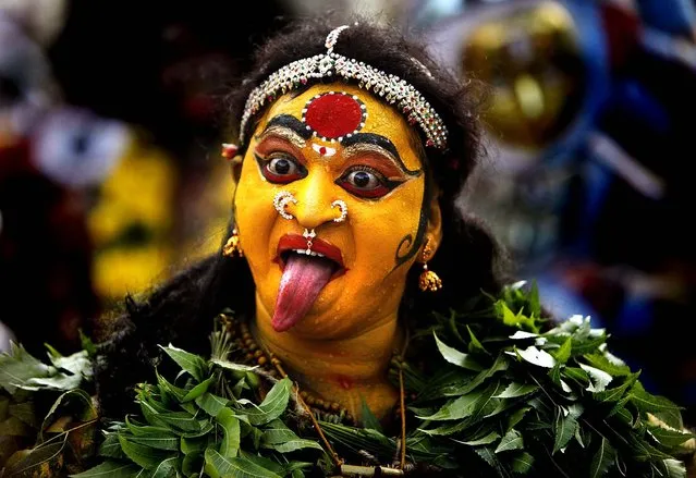 A Hindu woman dressed as the goddess Mahakali performs during a “Bonalu” festival in Hyderabad, India on July 16, 2012. Bonalu is a Hindu folk festival of the Telangana region in the Indian state of Andhra Pradesh. (Photo by Mahesh Kumar A/Associated Press)