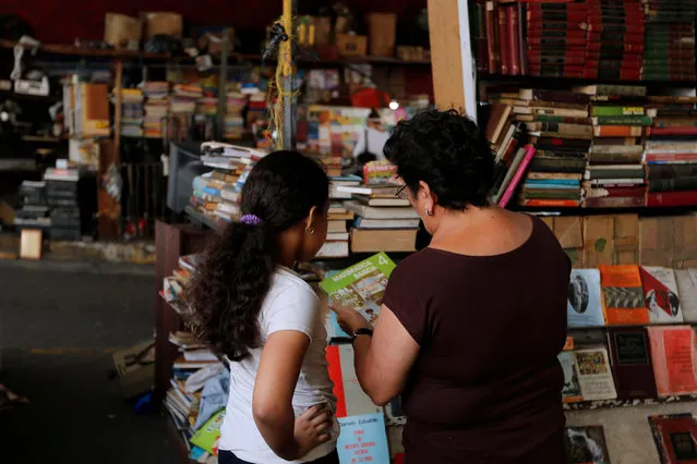 A woman and a child look at a book at a street book stall trade in Caracas, Venezuela, July 3, 2016. (Photo by Carlos Jasso/Reuters)