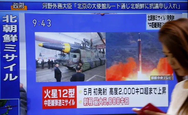 A woman walks past a TV screen broadcasting news of North Korea's missile launch, in Tokyo, Tuesday, August 29, 2017. North Korea fired a ballistic missile from its capital Pyongyang that flew over Japan before plunging into the northern Pacific Ocean, officials said Tuesday, an aggressive test-flight over the territory of a close U.S. ally that sends a clear message of defiance as Washington and Seoul conduct war games nearby. (Photo by Shizuo Kambayashi/AP Photo)