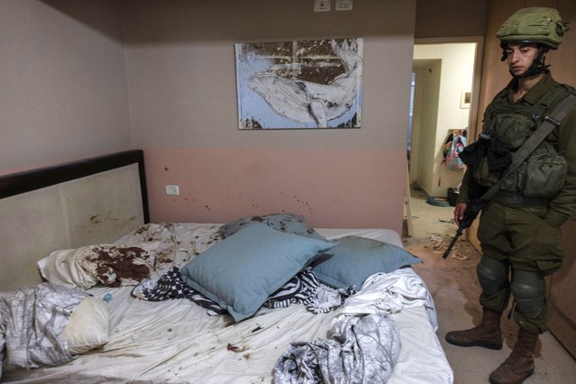 Israeli soldiers inside the bedroom of a home where people were killed by Palestinian fighters at Kibbutz Be’eri near the Gaza border on October 14, 2023. Be’eri, was one of first places targeted by militants who breached the border early last Saturday morning. (Photo by Heidi Levine for The Washington Post).