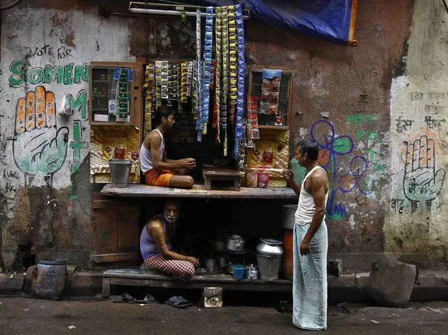 A man drinks tea while standing next to a roadside tea shop in Kolkata September 2, 2014. (Photo by Rupak De Chowdhuri/Reuters)