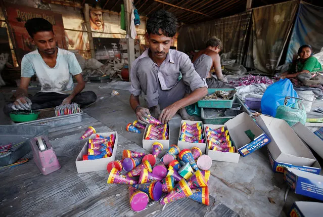 Workers make firecrackers at a factory ahead of Diwali, the Hindu festival of lights, on the outskirts of Ahmedabad, India October 6, 2017. (Photo by Amit Dave/Reuters)