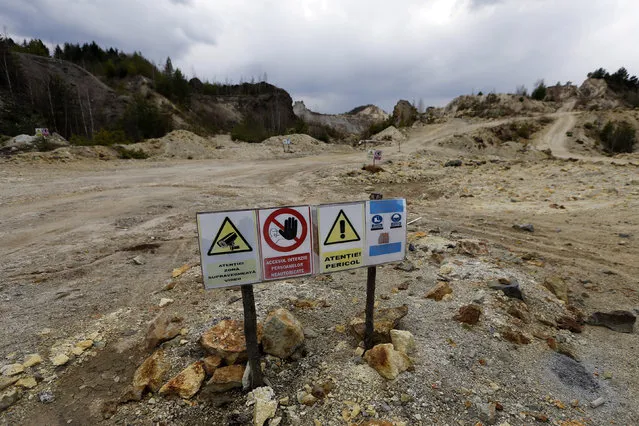Warning signs are seen next to an old quarry near Rosia Montana, central Romania, March 24, 2014. (Photo by Bogdan Cristel/Reuters)