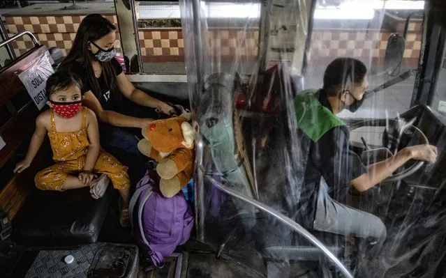 A driver sits behind a plastic covering for protection inside a bus on the first day of relaxed quarantine measures on June 1, 2020 in Caloocan, Metro Manila, Philippines. The sign reads “Please help, we are jeepney drivers. Our families are hungry”. The Philippines on Monday eased one of the world's longest and strictest lockdowns in the world to curb the spread of the coronavirus, even as cases of the virus in the country continue to rise. The 80-day lockdown in parts of the country has left millions of Filipinos jobless and hungry, and even as free mass testing for COVID-19 remains absent in most parts of the country, there has been a spike in reported cases in the past week. The Philippines' Department of Health has so far reported 18,086 cases of the coronavirus in the country, with at least 957 recorded fatalities. (Photo by Ezra Acayan/Getty Images)