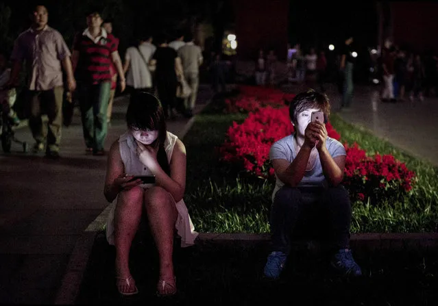 Chinese women use their smartphones in a park on September 10, 2014 in Beijing, China. China tightened censorship on mobile messaging apps last month and blocked a number of foreign chat services, according to media reports. (Photo by Kevin Frayer/Getty Images)