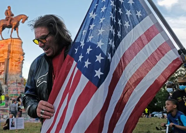 Brian Coleman, who calls himself “the Space Cowboy”, holds a U.S. flag as protesters rally against racial inequality and the death in Minneapolis police custody of George Floyd, around the statue of Confederate General Robert E. Lee in Richmond, Virginia, U.S. June 12, 2020. (Photo by Jay Paul/Reuters)