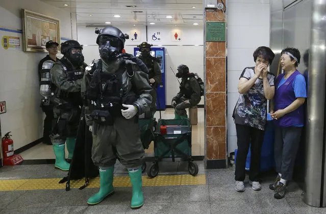 South Korean army soldiers stand as women watch during an anti-terror drill as part of the Ulchi Freedom Guardian exercise, at Yoido Subway Station in Seoul, South Korea, Tuesday, August 23, 2016. South Korea and the United States began annual military drills Monday despite North Korea's threat of nuclear strikes in response to the exercises that it calls an invasion rehearsal. (Photo by Ahn Young-joon/AP Photo)