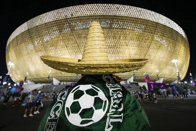 A Mexico's fan wearing a sombrero walks towards the Lusail Stadium before the World Cup group C soccer match between Argentina and Mexico at the Lusail Stadium in Lusail, Qatar, Saturday, November 26, 2022. (Photo by Pavel Golovkin/AP Photo)