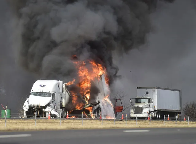 Two semitrailers in the southbound lanes of I-65 burn after a collision between three trucks near mile marker 43 near Seymour, Ind., Wednesday, January 10, 2018. One of the trucks involved in the accident was carrying four types of hazardous materials. Authorities have evacuated some homes in the area as a precaution and closed down the northbound and southbound lanes of the interstate. (Photo by Aaron Piper/The Republic via AP Photo)