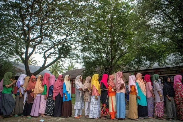 Rohingya refugees stand in line to get aid at their temporary shelter in Pidie, Aceh province, Indonesia on December 29, 2022, in this photo taken by Antara Foto. (Photo by Nova Wahyudi/Antara Foto via Reuters)