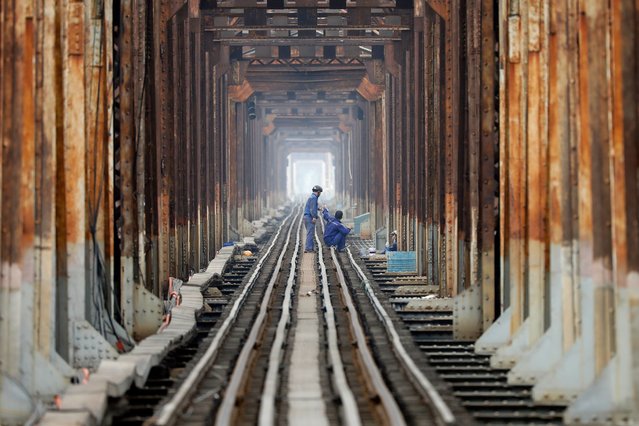 Workers check railway tracks at Long Bien Bridge in Hanoi, Vietnam, 21 April 2025. Vietnam maintains its GDP growth target for 2025 at 8 percent despite tariff risks. (Photo by Luong Thai Linh/EPA/EFE)