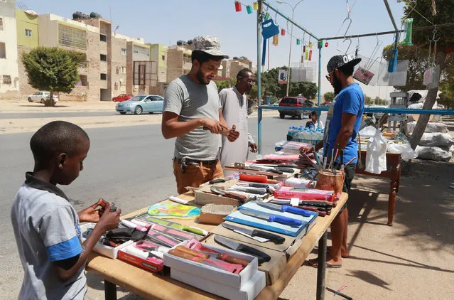 A vendor (R) sells knives and coal ahead of the Eid al-Adha festival, in Benghazi, Libya September 7, 2016. (Photo by Esam Omran Al-Fetori/Reuters)
