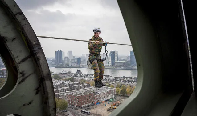 A member of The Royal Netherlands Army climbs on a rope which is attached to The Hef Bridge in the centre of Rotterdam, The Netherlands on 18 October 2015. The exercise is part of a week full of training of the Dutch army which takes place in different parts of Rotterdam. (Photo by Lex van Lieshout/EPA)