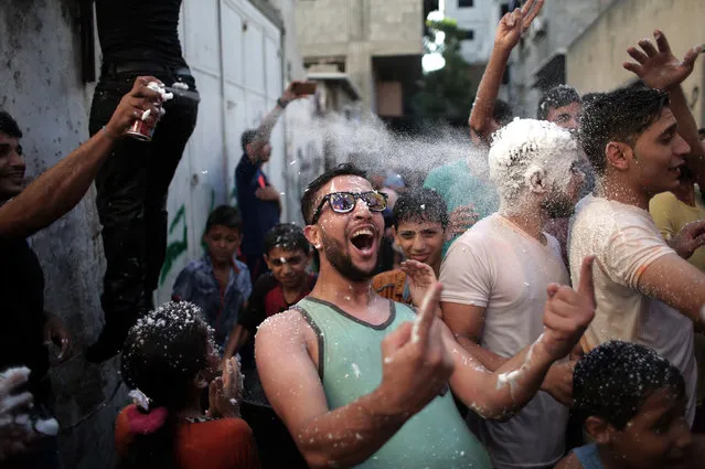 Palestinian youth and children spray each other with foam, water and paint in the narrow streets of Jebaliya refugee camp, northern Gaza Strip, Friday, September 23, 2016. The activity was organized by the refugee camp residents to bring joy to the children. (Photo by Khalil Hamra/AP Photo)