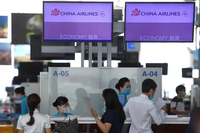 Airline workers check in passengers in the departure terminal at Noi Bai International Airport in Hanoi on September 16, 2020. Vietnam said September 16 it will resume international commercial flights to and from six Asian destinations, months after a suspension due to the COVID-19 coronavirus. (Photo by Nhac Nguyen/AFP Photo)