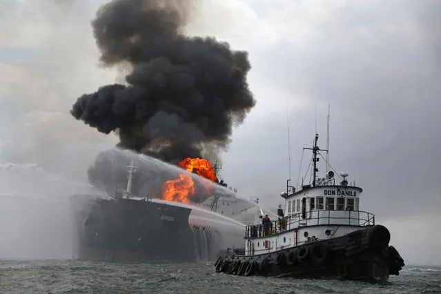 A firefighting boat works to extinguish a fire aboard the tanker Burgos about seven nautical miles off the coast of the port city of Boca del Rio, Mexico, Saturday September 24, 2016. The tanker was carrying about 168,000 barrels of gasoline and diesel fuel. Mexico's Navy rescued 31 crew members and no injuries were reported. There were no immediate reports of fuel spills and the cause of the fire was unknown. (Photo by Ilse Huesca/AP Photo)