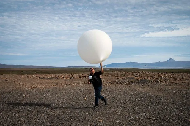 A weather scientist sends a balloon in the air, on December 25, 2022, at the basement located on the Kerguelen Island, also known as the Desolation Islands, a group of islands in the sub-Antarctic. They are among the most isolated places on Earth, located more than 3,300 kilometres from Madagascar. There are no indigenous inhabitants, but France maintains a permanent presence of 45 to 100 soldiers, scientists, engineers, and researchers. Port-aux-Français, a scientific base. Facilities there include scientific-research buildings, a satellite tracking station, dormitories, a hospital, a library, a gymnasium, a pub, and the chapel of Notre-Dame des Vents. (Photo by Patrick Hertzog/AFP Photo)