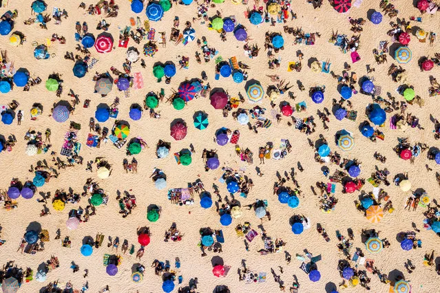 An aerial view of people enjoying the weather at Ipanema Beach on September 6, 2020 in Rio de Janeiro, Brazil. Residents of Rio de Janeiro and tourists disrespected the rules of the city and occupied the sands of the beaches. A municipal decree cleared beach vendors and permitted bathing in the sea. However, the use of chairs and tents on the sand is still prohibited. (Photo by Buda Mendes/Getty Images)