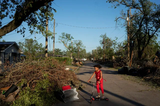 Iyana Sells, 9, plays on her street which is still lined with debris from Hurricane Laura the day after Hurricane Delta swept through Lake Charles, Louisiana, U.S., October 10, 2020. (Photo by Kathleen Flynn/Reuters)
