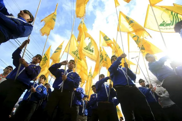 Lebanon's Hezbollah scouts carry their parties flag while marching at the funeral of three Hezbollah fighters who were killed while fighting alongside Syrian army forces in Syria in Nabatieh town, southern Lebanon, October 27, 2015. (Photo by Ali Hashisho/Reuters)