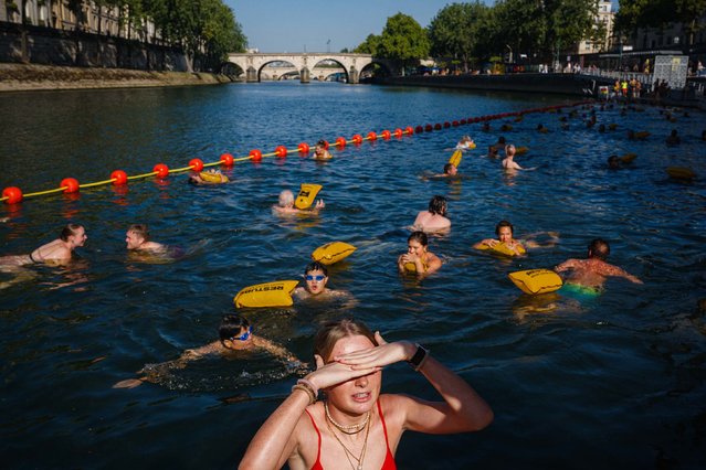 People swim at the Bras Marie safe bathing site on the river Seine in Paris on August 12, 2025. France continues to suffocate with 14 departments in the southwest and southeast on red alert for heatwave on August 12, 2025, an exceptional heat wave, even for the month of August, which is prompting authorities to increase precautionary measures. (Photo by Dimitar Dilkoff/AFP Photo)