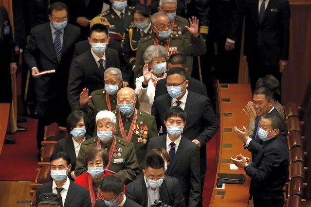 Delegates wearing face masks to help curb the spread of the coronavirus applaud as masked veteran soldiers arrive to attend the commemorating conference on the 70th anniversary of China’s entry into the 1950-53 Korean War, at the Great Hall fo the People in Beijing, Friday, October 23, 2020. (Photo by Andy Wong/AP Photo)
