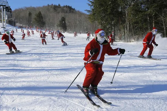 Skiers and snowboarders dressed as Santa Claus participate in a charity run down a slope at Sunday River Ski Resort in Newry, Maine December 7, 2014. (Photo by Brian Snyder/Reuters)